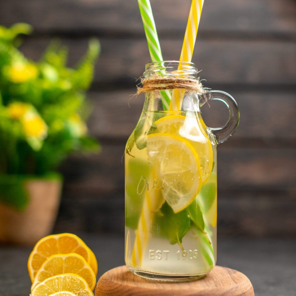 front-view-lemonade-wooden-serving-board-lemon-slices-potted-plant-brown-surface